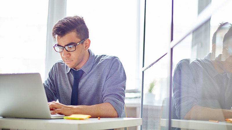 471493366 Seated man working with laptop
