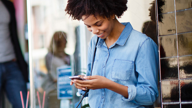 purchase-alert-woman-cell-800x450 Woman looking at her cell phone